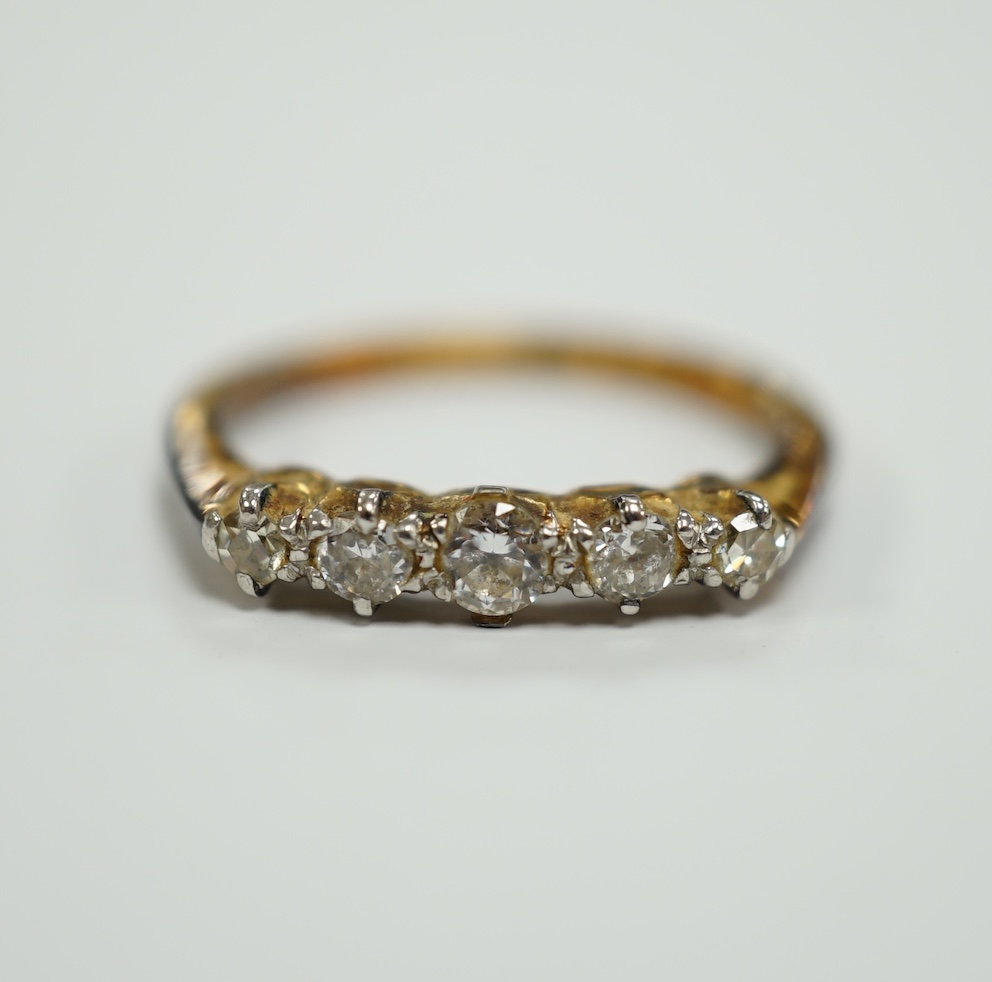 An early 20th century 18ct, plat and graduated five stone diamond chip set half hoop ring, size H, gross weight 2.2 grams.